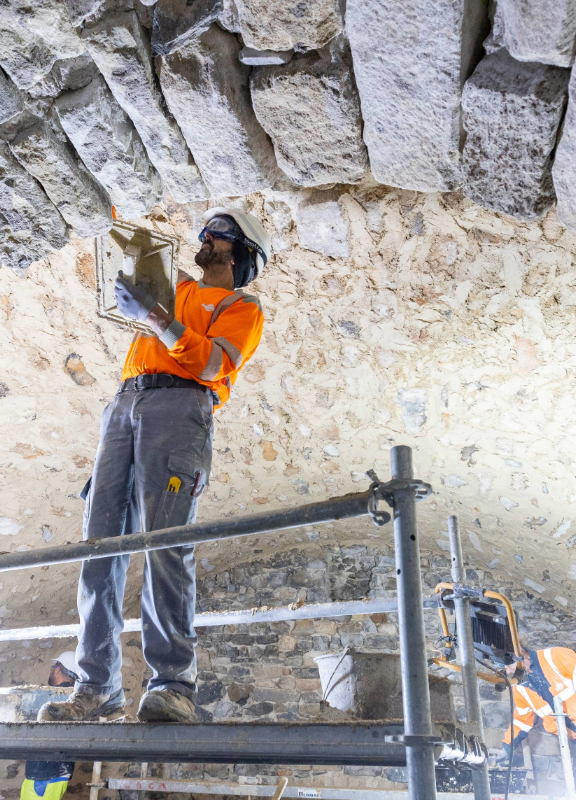 des personnes en train de travailler à l'intérieur d'une cave voutée