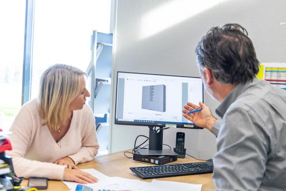 une cliente avec un conseiller devant un plan 3D